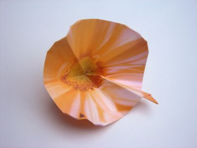folding an orange origami flower
