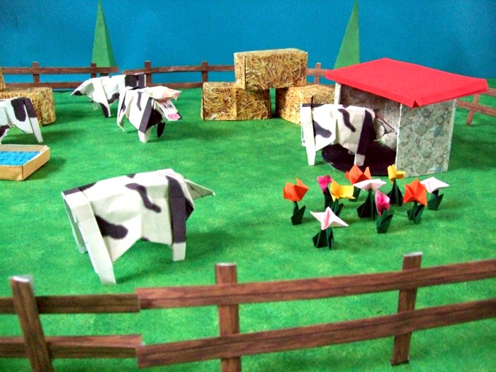 origami cows in a large scenery