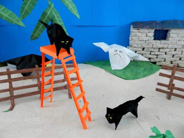twee zwarte katten bij een hoge ladder