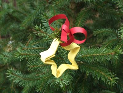 papieren sterretje aan een rood lint in de kerstboom