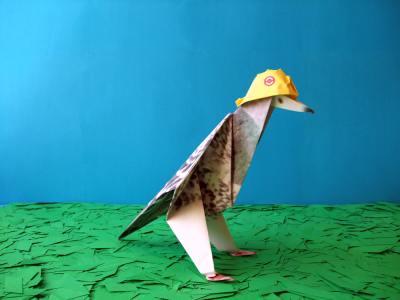 duif van papier met een helm op zijn kop
