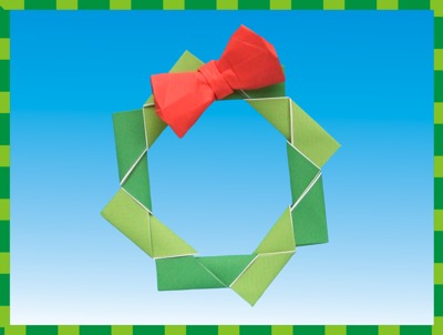 modular origami christmas wreath with a red bow on it