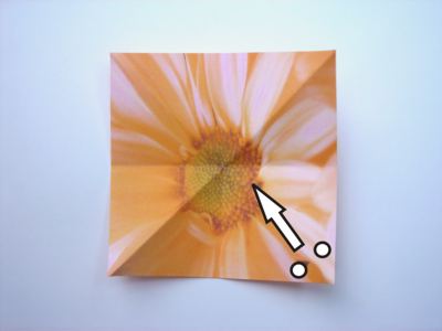 folding an orange origami flower