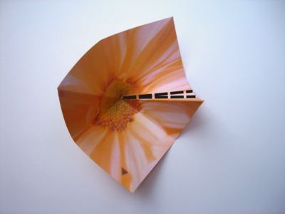 folding an orange origami flower