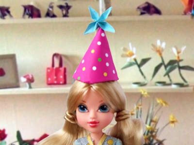 doll with an origami party hat on her head