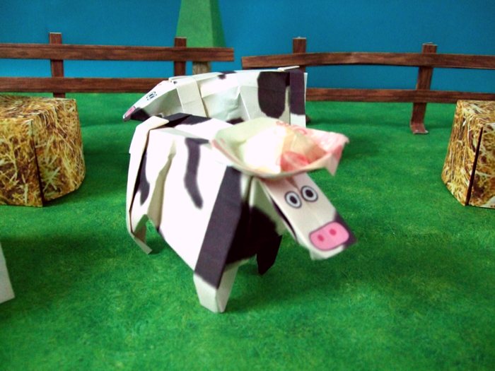 grappige papieren koe met een hoedje op zijn hoofd