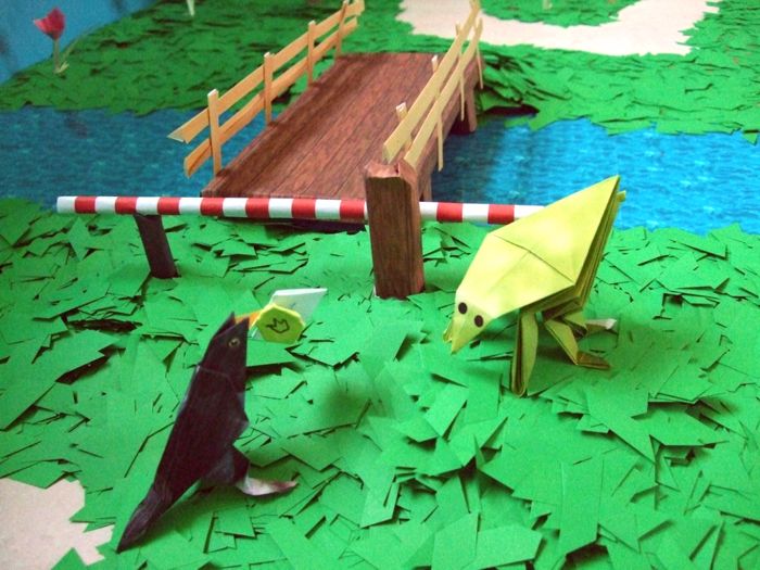 origami grasshopper standing next to a kirigami bridge origami grasshopper standing next to a kirigami bridge