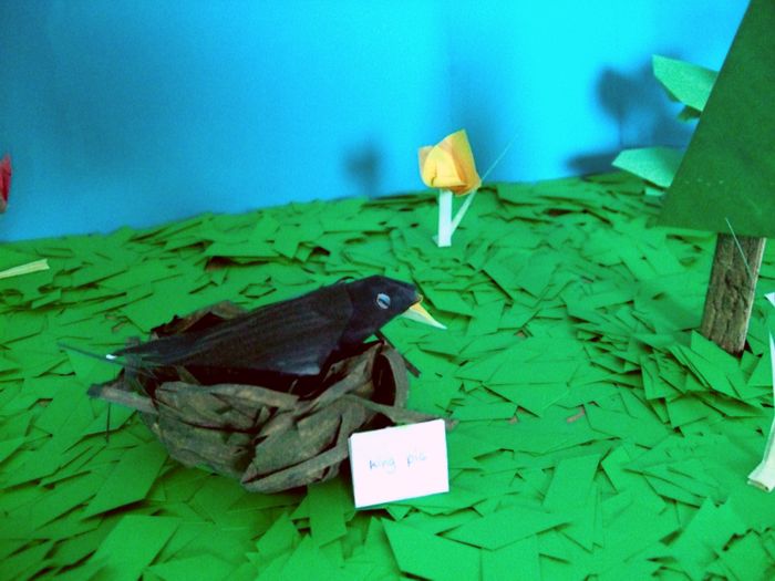 merel van papier in een vogelnestje