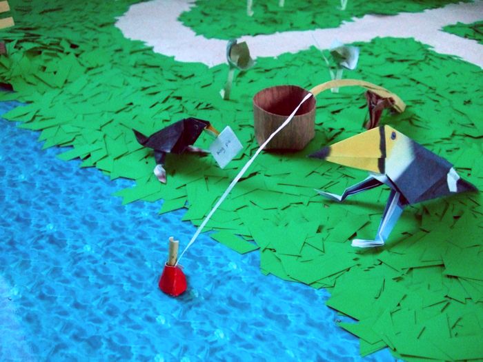 toekan van papier die zit te vissen aan een rivier toekan van papier die zit te vissen aan een rivier
