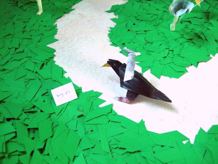 bird with an origami fish on it's back bird with an origami fish on it's back