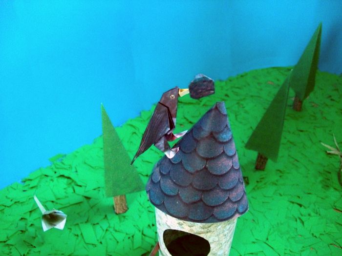 merel van papier op het dak van een vogelhuisje merel van papier op het dak van een vogelhuisje