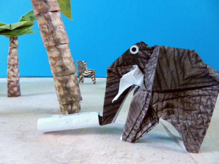 papieren olifant die een schatkaart oprolt papieren olifant die een schatkaart oprolt