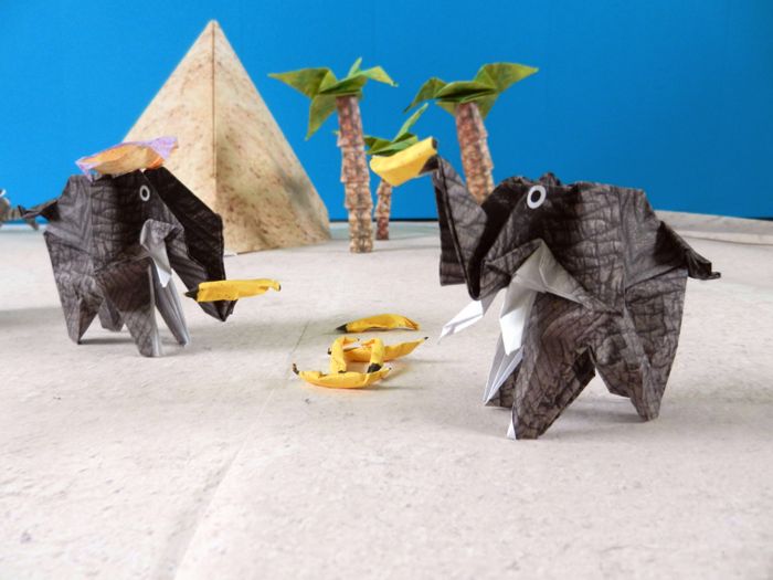 two funny origami elephants eating some bananas two funny origami elephants eating some bananas