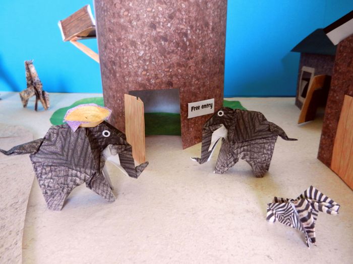 twee olifanten bij de ingang van een toren van papier