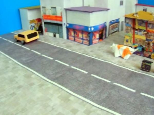 dikke poes van papierkunst die door een stadje loopt dikke poes van papierkunst die door een stadje loopt